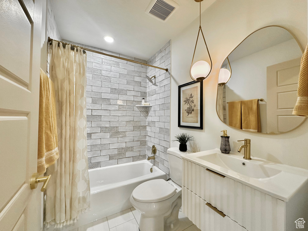 Bathroom featuring vanity, shower / tub combo, and tile patterned floors