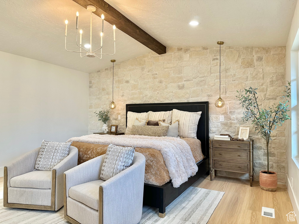 Bedroom featuring light wood finished floors and a chandelier
