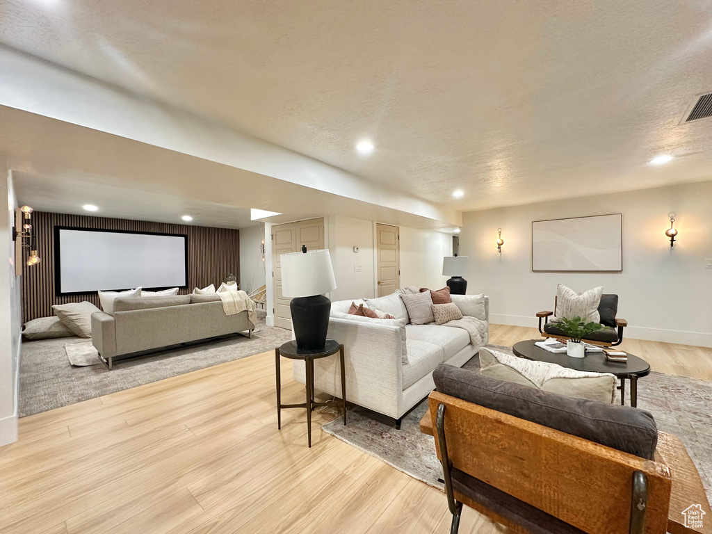 Living area with light wood-style floors and recessed lighting