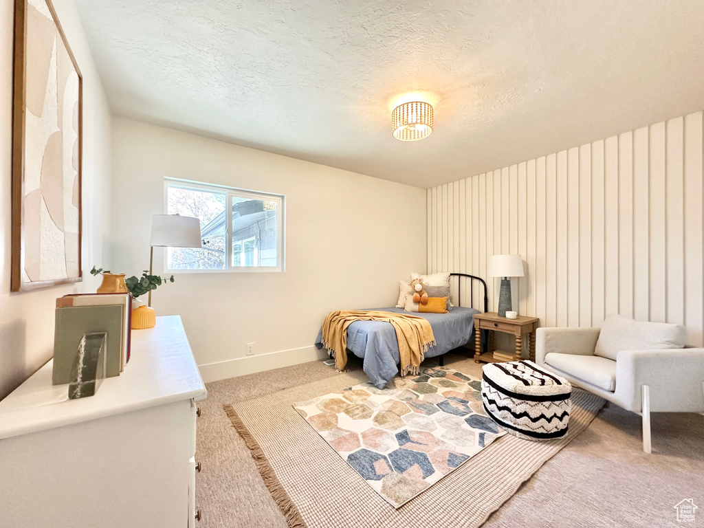 Carpeted bedroom with baseboards and a textured ceiling