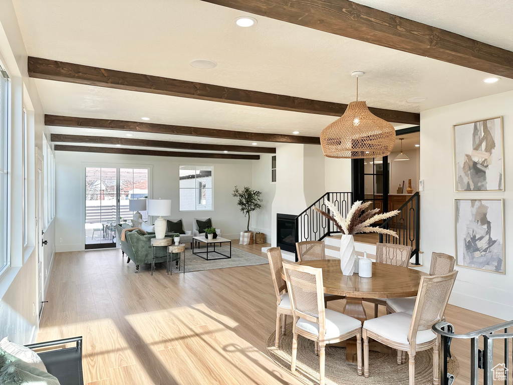 Dining space featuring beamed ceiling, light wood-style floors, stairway, and recessed lighting