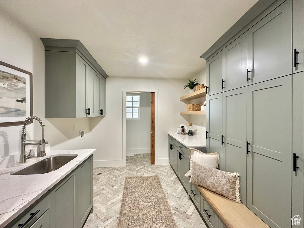Laundry room with cabinet space, washer hookup, and brick floors