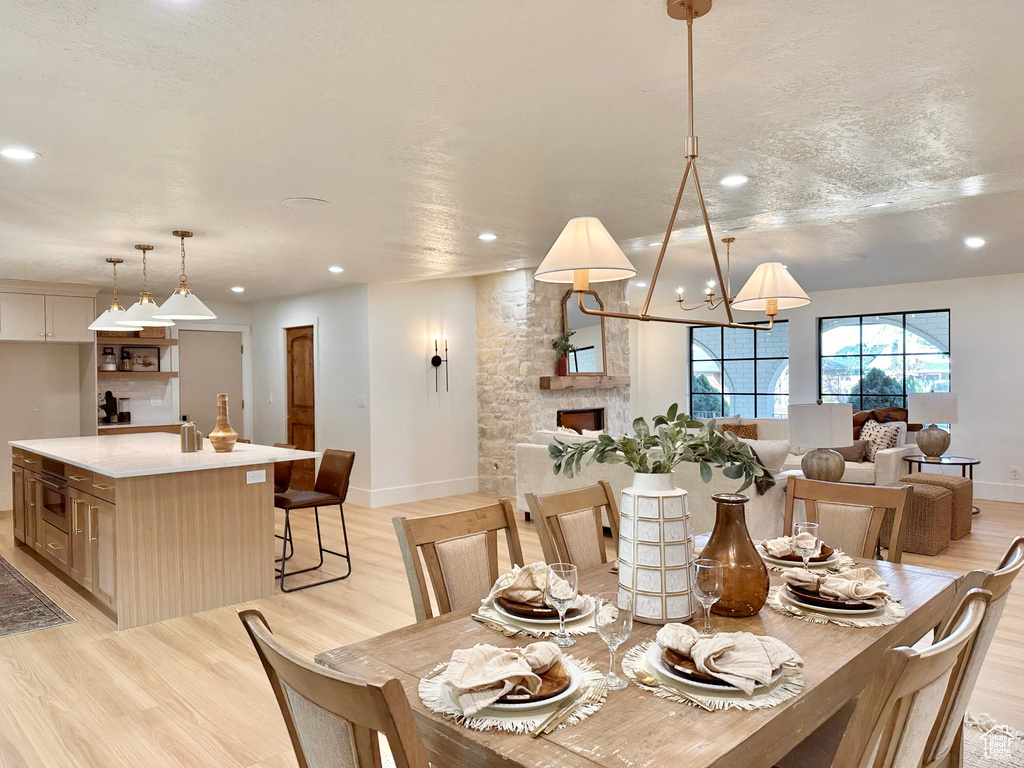 Dining room with recessed lighting, light wood-style flooring, and a chandelier