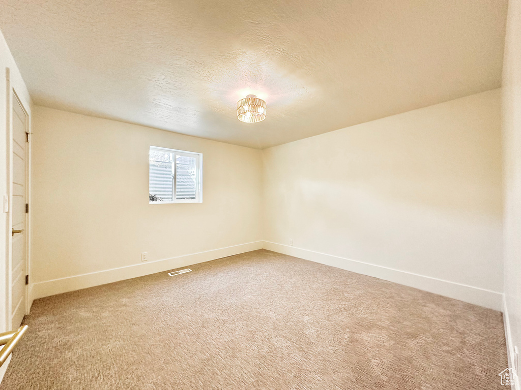 Unfurnished room with carpet flooring and a textured ceiling
