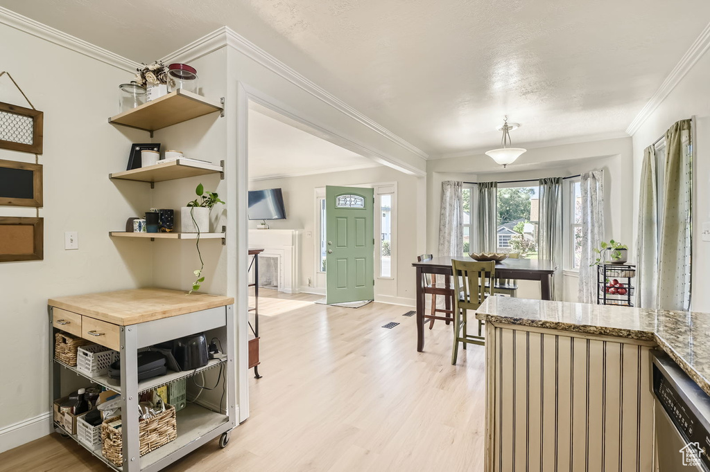 Dining area featuring light wood-type flooring, ornamental molding, and baseboards