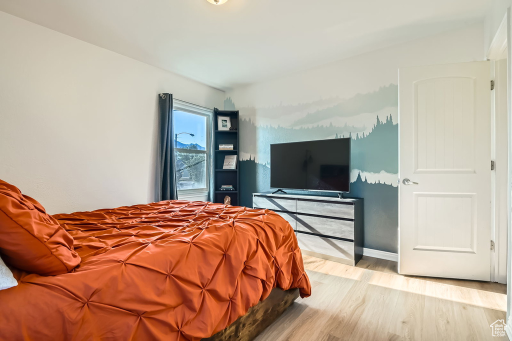 Bedroom with light wood-style floors and baseboards