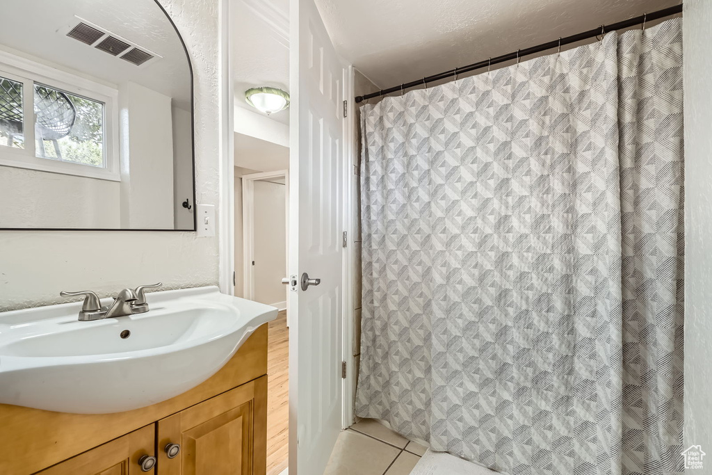 Bathroom featuring vanity, tile patterned floors, and a shower with shower curtain