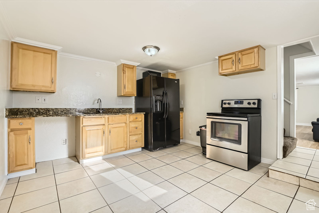 Kitchen featuring stainless steel electric range oven, black fridge, light brown cabinets, light tile patterned floors, and crown molding