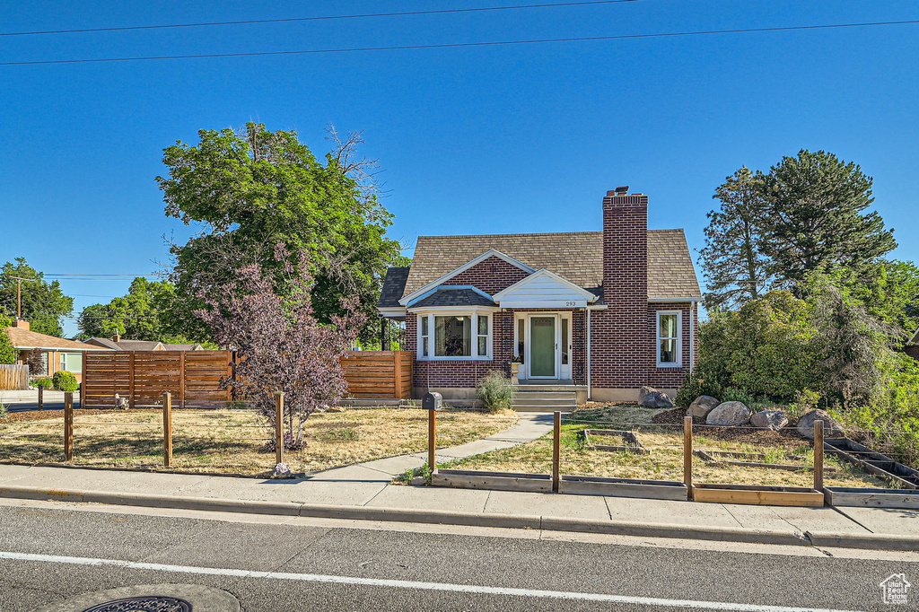 Bungalow featuring a chimney, brick siding, and roof with shingles
