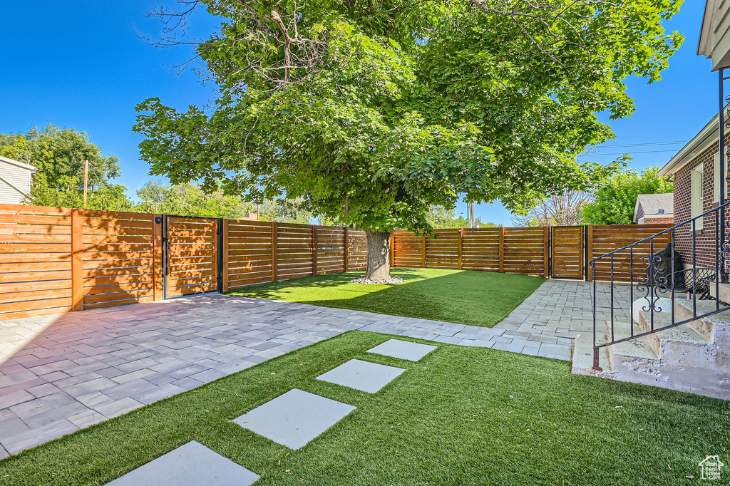 View of yard featuring a patio area and a gate