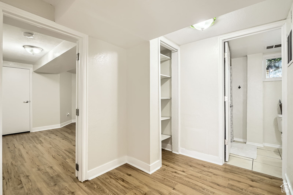 Hall with light wood finished floors and baseboards