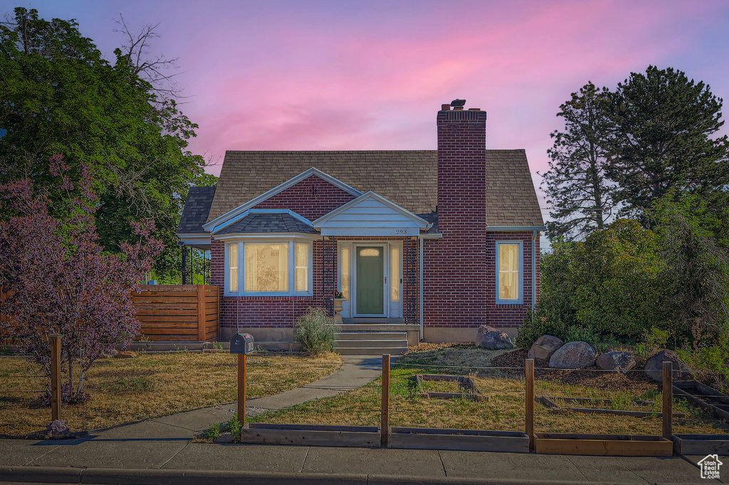 Bungalow-style home with brick siding and a chimney