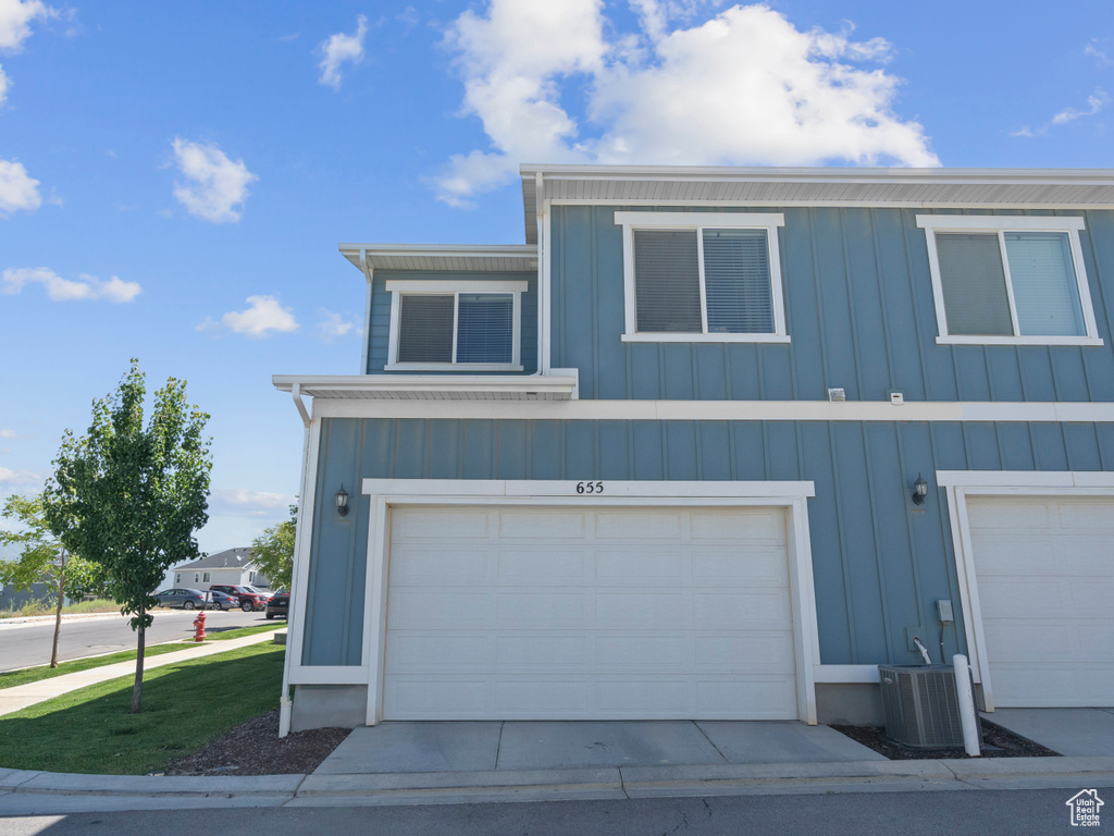 View of front of house with board and batten siding and an attached garage