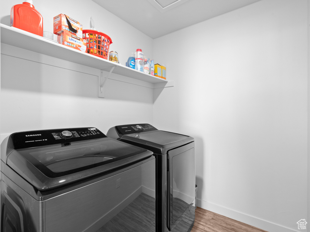 Laundry area featuring separate washer and dryer and wood finished floors