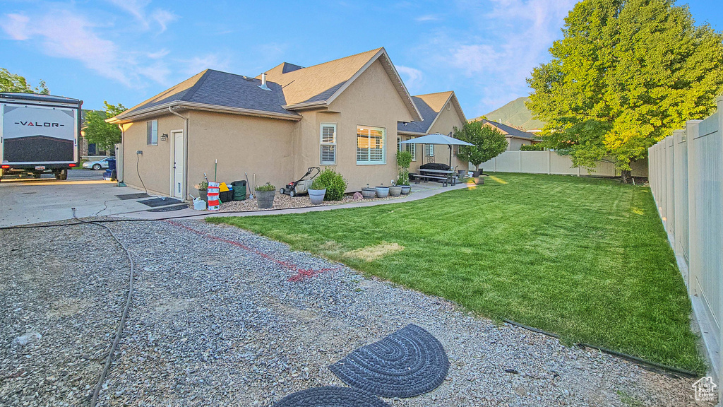 View of home's exterior featuring stucco siding, a fenced backyard, and roof with shingles