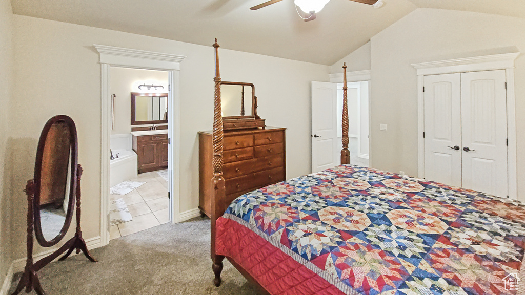 Carpeted bedroom featuring lofted ceiling, a closet, a ceiling fan, and connected bathroom
