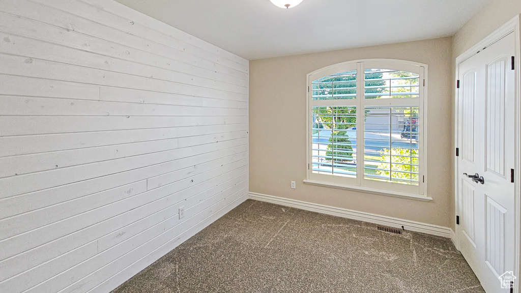 Empty room with dark carpet and baseboards