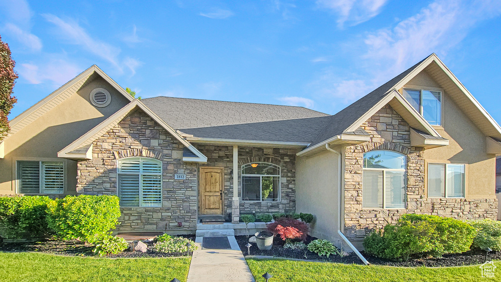 View of front of home featuring stone siding and stucco siding