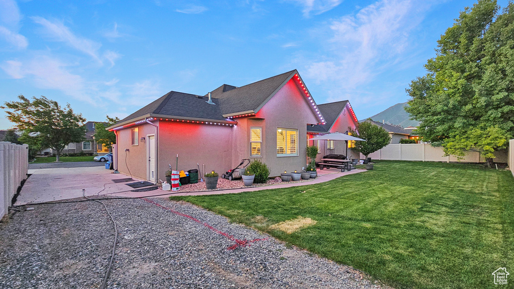 Back of house featuring stucco siding, a patio, and a shingled roof