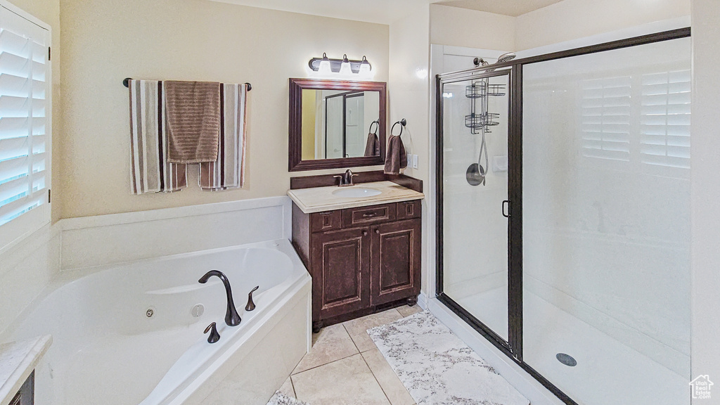 Full bathroom with vanity, a stall shower, a tub with jets, and tile patterned floors