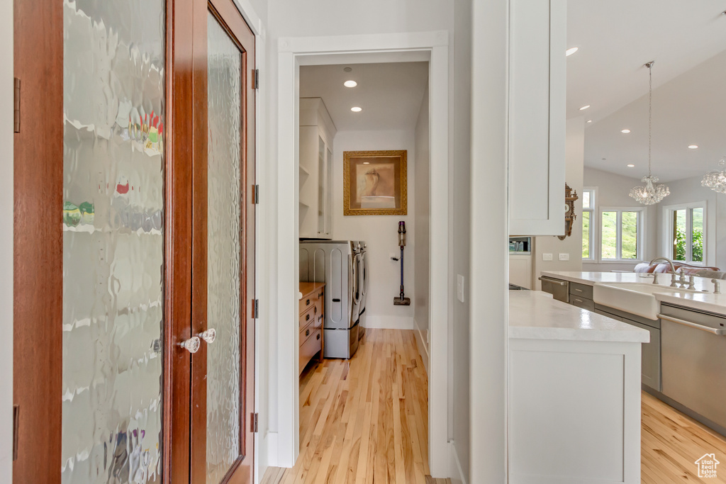 Hall with washer and dryer, light wood-style flooring, a chandelier, a sink, and recessed lighting