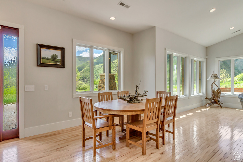 Dining area with light wood-type flooring, baseboards, recessed lighting, and vaulted ceiling