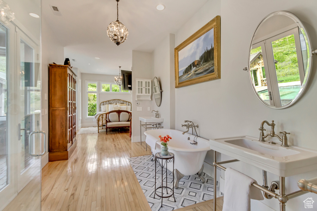 Hall featuring a chandelier, french doors, light wood-type flooring, recessed lighting, and baseboards