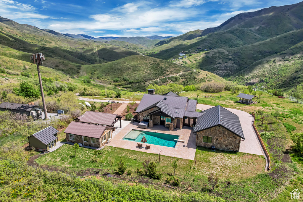 View of subject property with a pool and a mountainous background