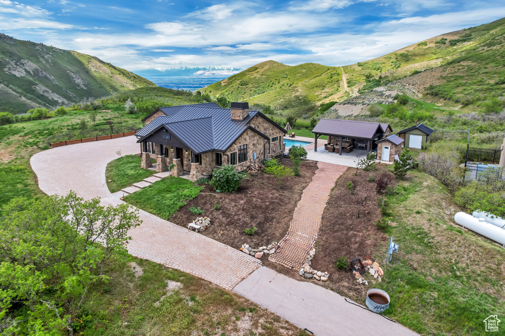 Aerial view of property and surrounding area featuring a mountainous background