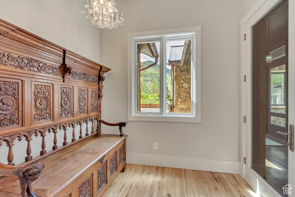 Mudroom with wood finished floors, a chandelier, and baseboards