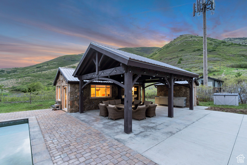 View of patio / terrace featuring a gazebo, an outdoor living space, a hot tub, a mountain view, and an outdoor pool
