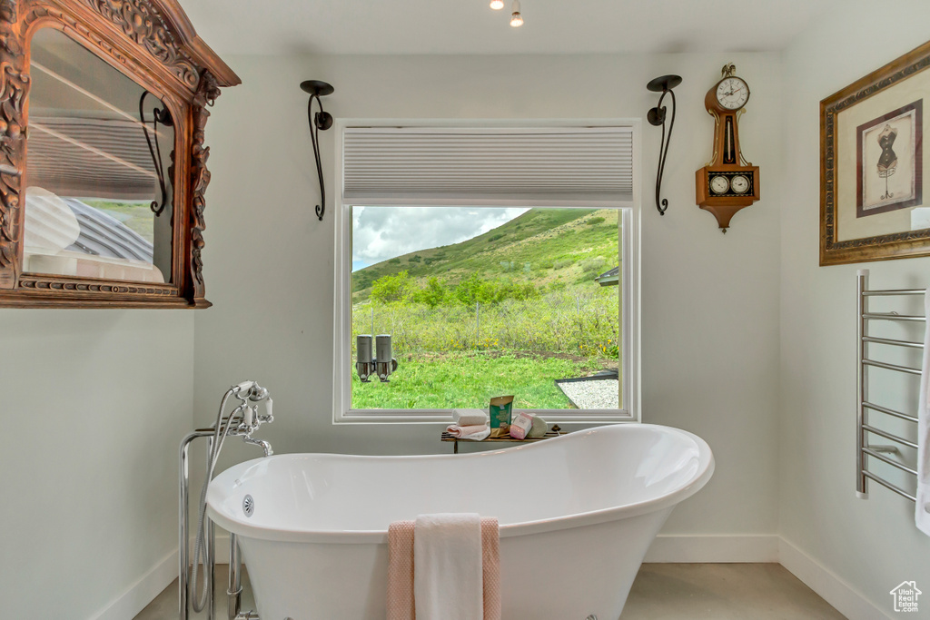 Bathroom featuring baseboards and a freestanding tub