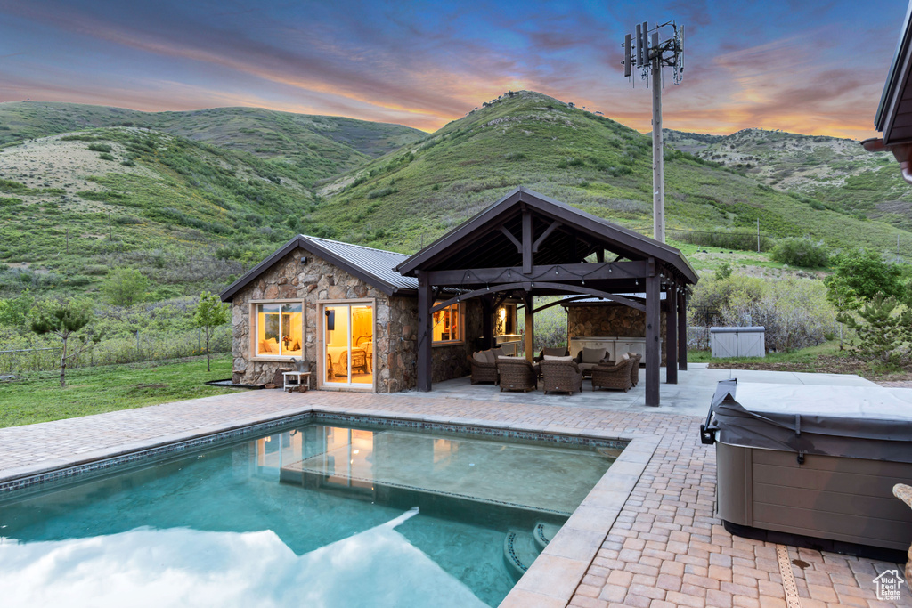 Outdoor pool with an outdoor living space, a hot tub, an outdoor structure, and a patio