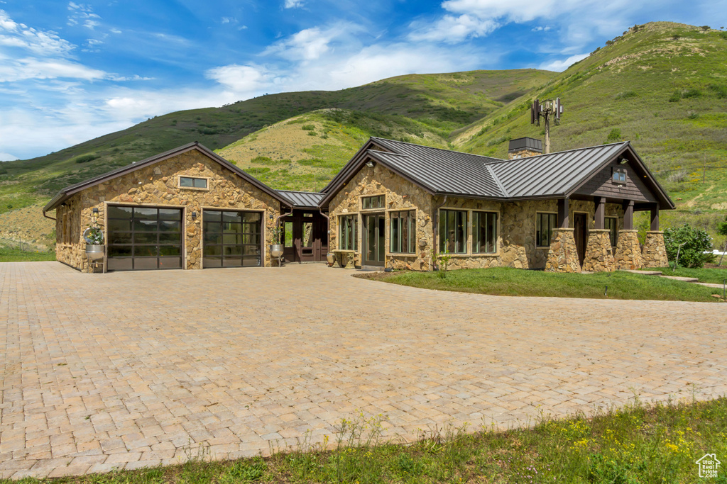 View of front of property featuring a standing seam roof, stone siding, and a mountain view