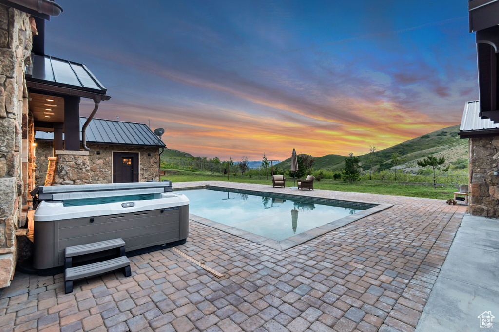Swimming pool featuring a patio area, a mountain view, and a hot tub