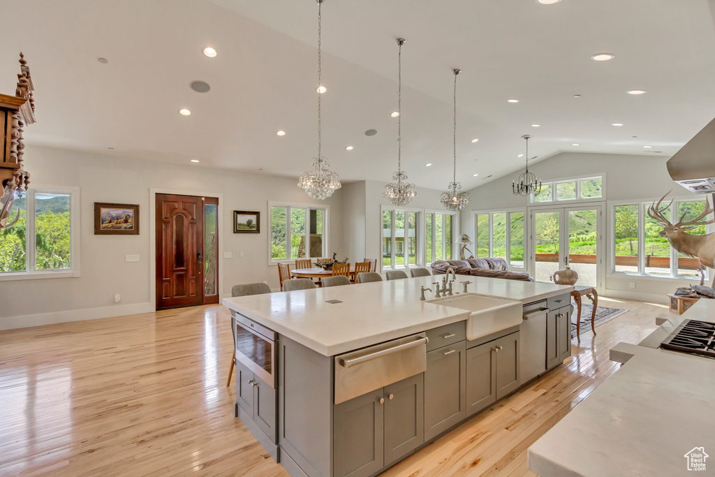 Kitchen with a warming drawer, gray cabinetry, a sink, a chandelier, and appliances with stainless steel finishes