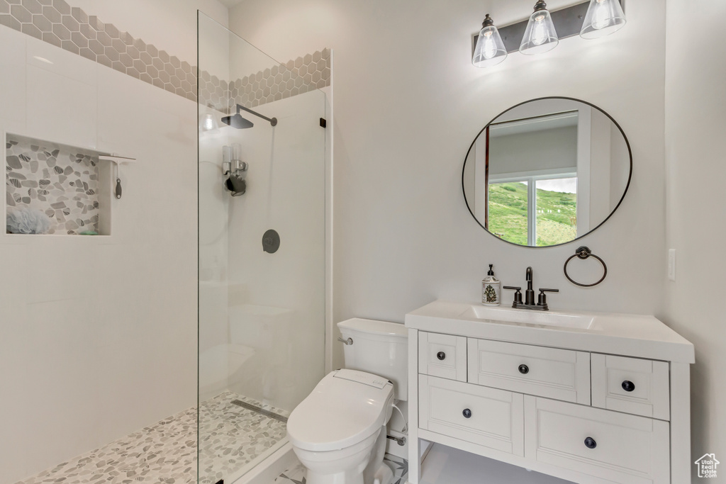 Bathroom featuring walk in shower, toilet, and vanity