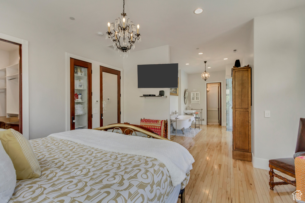 Bedroom featuring a chandelier, light wood finished floors, recessed lighting, and baseboards