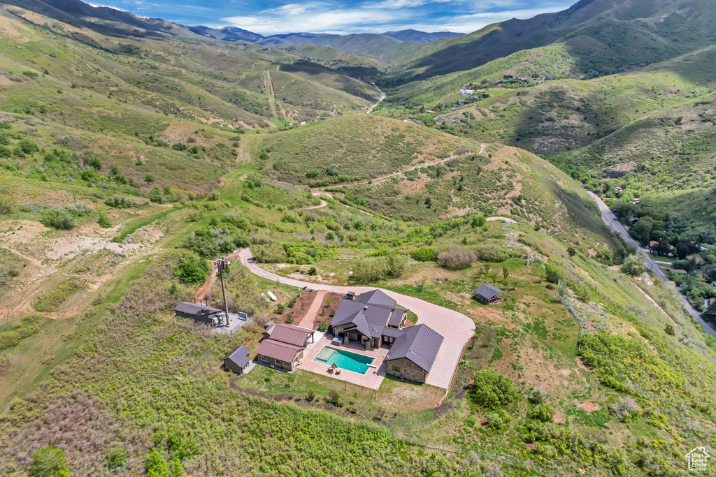 Aerial view of property and surrounding area featuring a mountain backdrop and a pool area