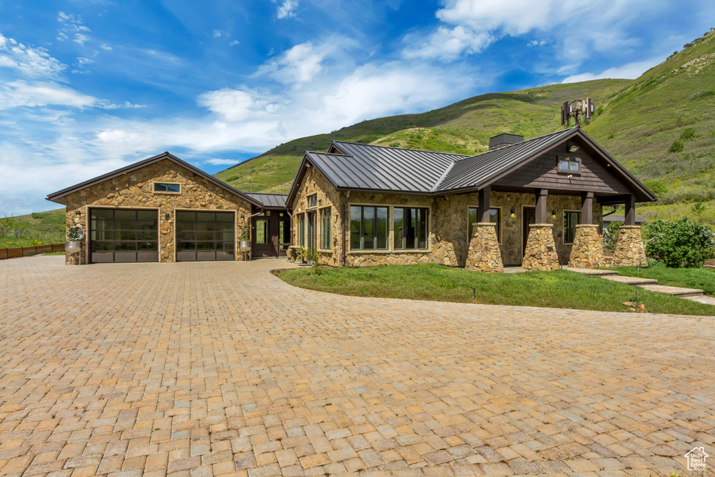 View of front of house featuring a standing seam roof, stone siding, and a mountain view