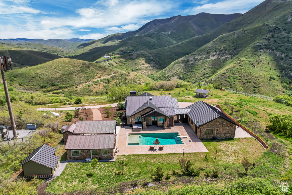 View from above of property with a pool area and a mountain backdrop