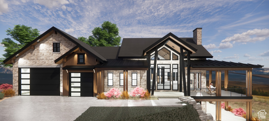 View of front facade featuring a standing seam roof, stone siding, a chimney, a metal roof, and concrete driveway