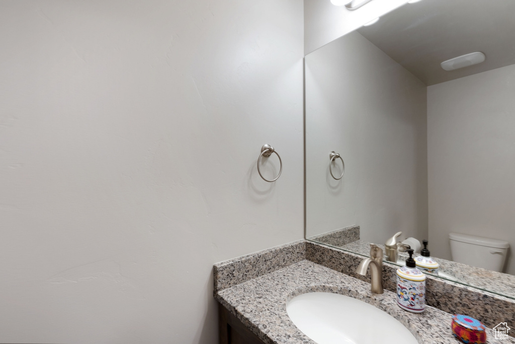 Half bathroom with vanity and toilet