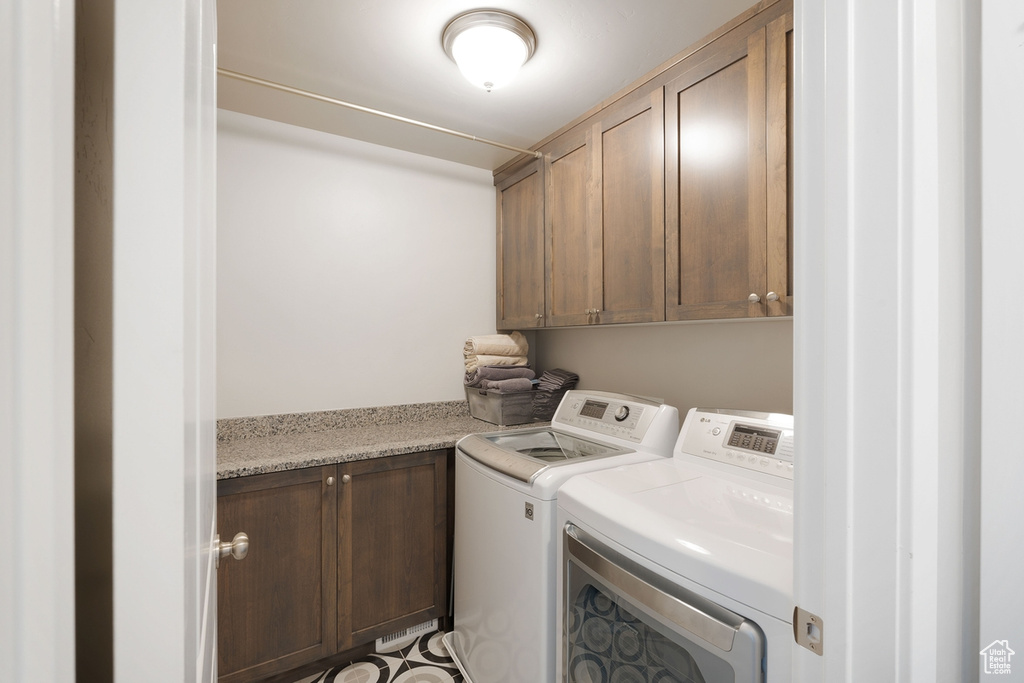 Laundry area with cabinet space and washer and clothes dryer