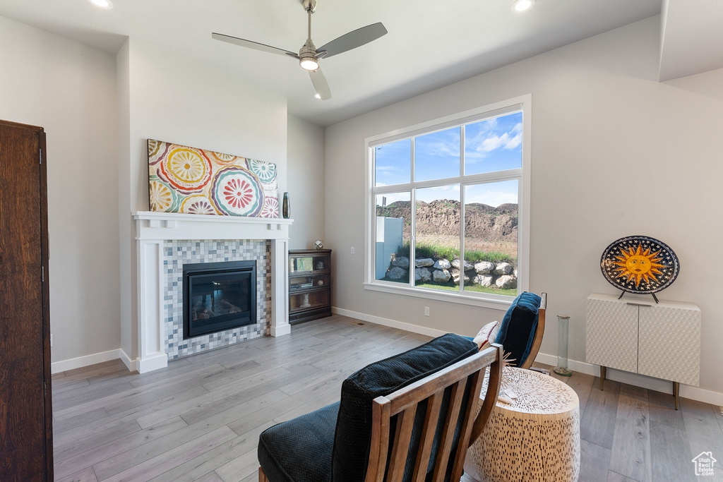 Living area with light wood-style floors, recessed lighting, a ceiling fan, a tile fireplace, and baseboards