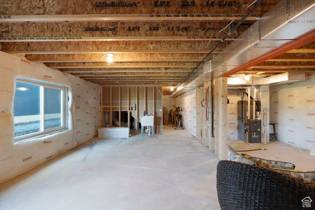Below grade area with heating unit and a sink