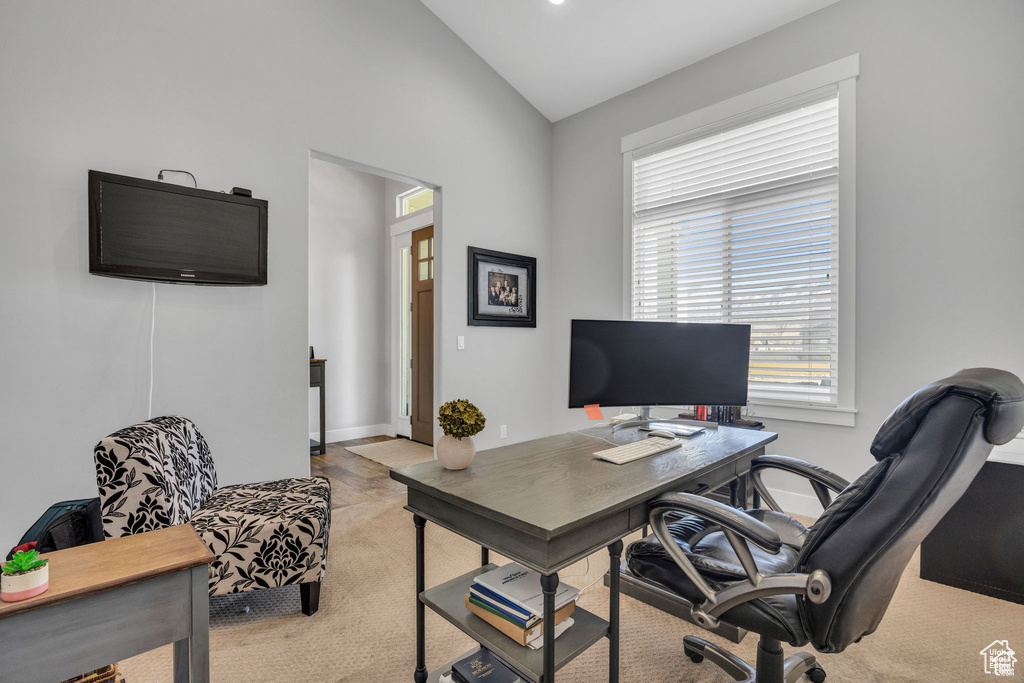 Office area with vaulted ceiling and light carpet