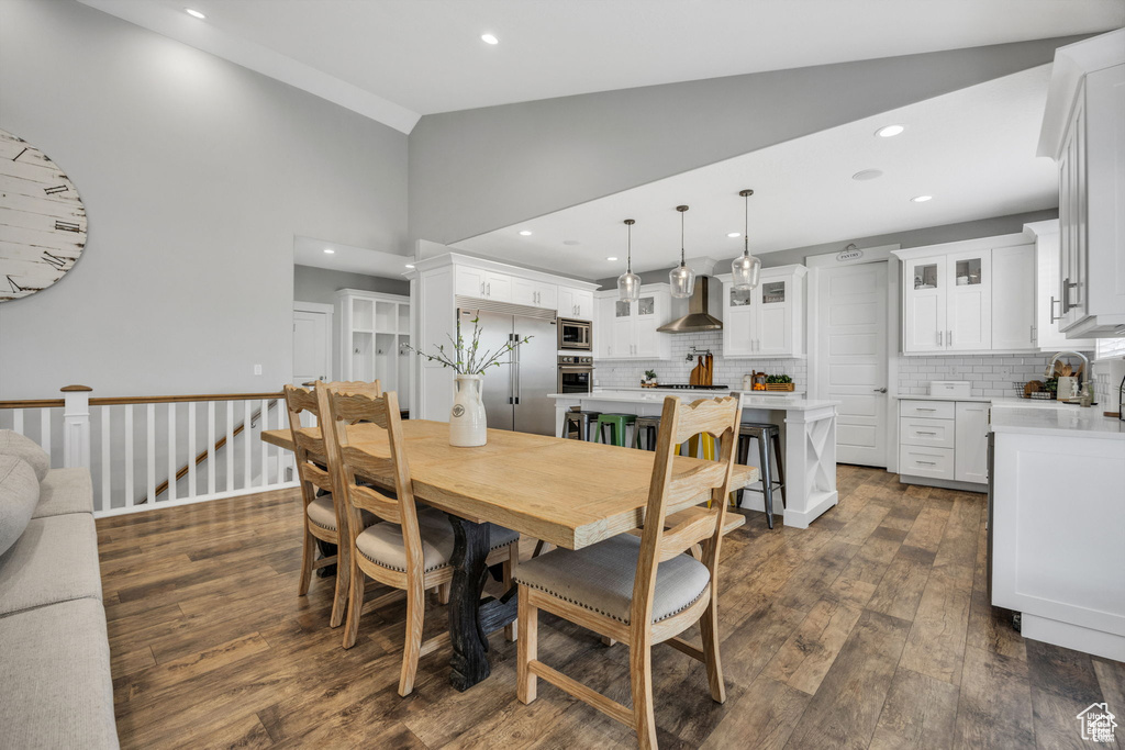 Dining space featuring dark wood-type flooring, recessed lighting, and high vaulted ceiling
