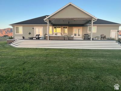 Back of property with outdoor lounge area, a lawn, and french doors