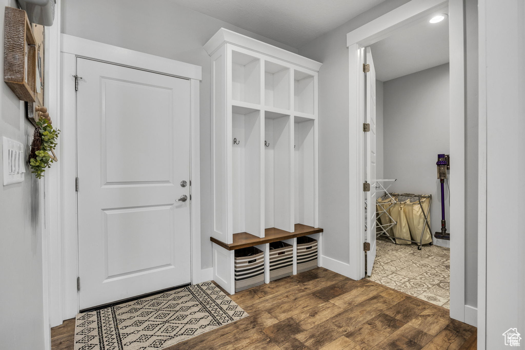 Mudroom featuring dark wood-style flooring and baseboards